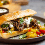 Italian Beef Sandwich with Roasted Garlic Aioli sliced on wooden board