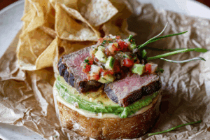 Carne Asada Torta with Roasted Poblano Salsa on a cutting board