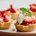 Overhead view of strawberry shortcake cookie cups on a rustic table