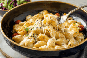 A steaming bowl of Creamiest Four Cheese Pasta with garnish.