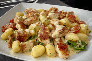 Skillet of creamy chicken and gnocchi in a rustic Italian kitchen.